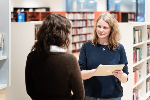 Metadata skal hjelpe bibliotek med å inspirere til mer lesing og enklere gjenfinning av litteratur. Bibliotekar hjelper låner på bildet.